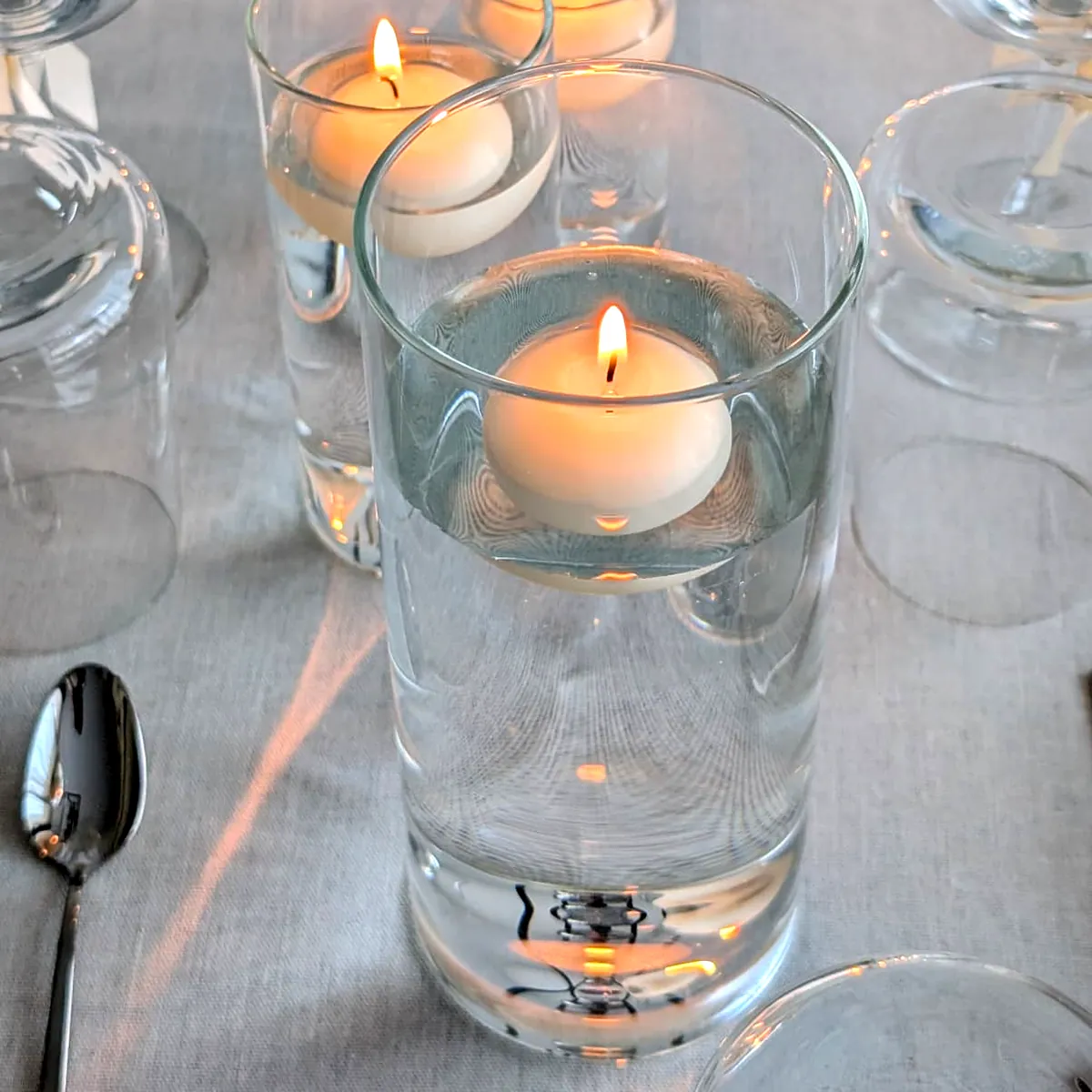 Glazen cilindervazen met water en een drijvende kaars